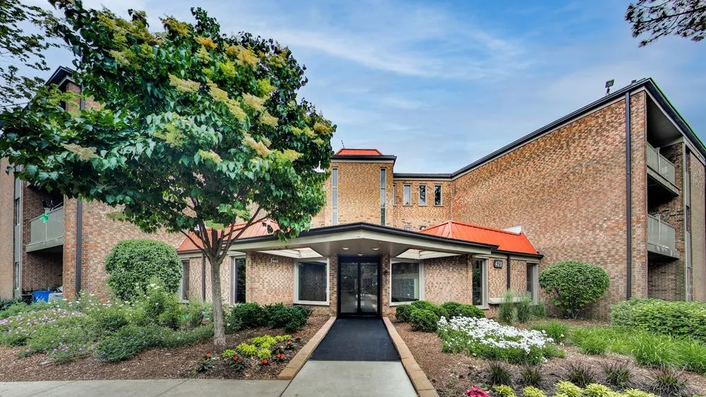 A building with a large entrance way and trees.