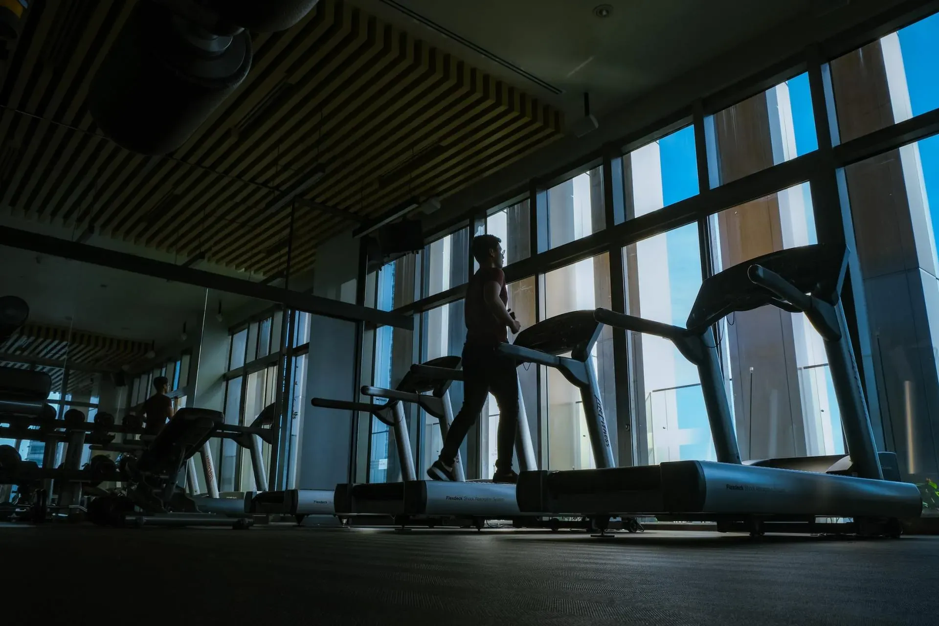 A group of people in the gym doing different exercises.